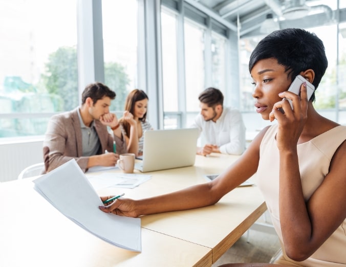 serious-businesswoman-with-documents-talking-on-P9Q6LX6@2x-min